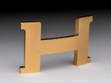 a small wooden letter h on a white surface