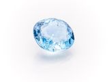 a close up of a blue topazte stone on a white surface