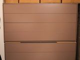 une commode marron dans un coin de la pièce