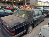 many old cars parked in a lot in a garage