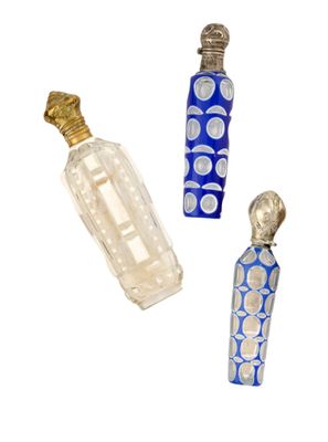 trois flacons de parfum posés l'un à côté de l'autre sur une surface blanche