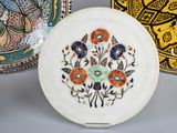 three decorative plates with designs on them sitting on a table