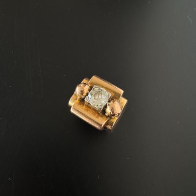 un gros plan d'un diamant serti dans une bague en or, posé sur une surface noire