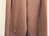 brown pants hanging on a hanger on a white wall