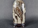 a close up of a vase with a giraffe on it on a table