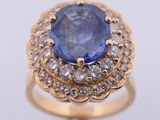a close up of a ring with a blue sapphire surrounded by white diamonds