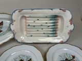 four plates with birds painted on them sitting on a table