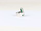 a close up of a silver ring with a green stone in it