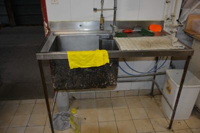 un évier sur lequel est posée une serviette jaune, dans une cuisine