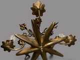a gold colored chandelier with flowers and leaves on it
