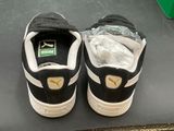 a pair of black and white sneakers on a black surface