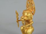gold figurine of a man with a sword in his hand