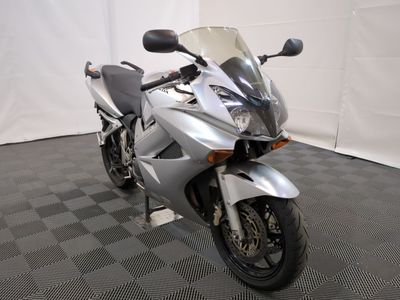 une moto argentée garée sur un sol à damier