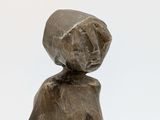 statue of a woman with a hat on her head and a bag on her back