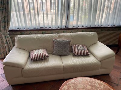 a white couch sitting in front of a window in a living room