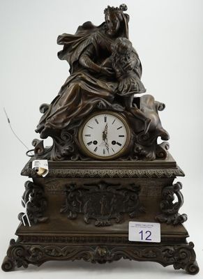 une horloge en bronze sur laquelle figurent une femme et un chien