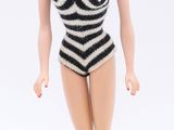 barbie doll wearing a black and white striped swimsuit and high heels