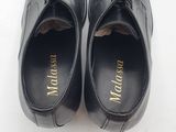 black leather shoes with gold lettering on the sole