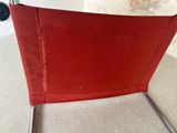 an image of a red chair sitting on top of a carpeted floor
