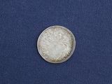 a close up of a silver coin on a blue cloth