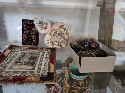 une vitrine en verre sur laquelle sont disposés divers objets décoratifs