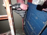 a man that is using a drill to fix a wall