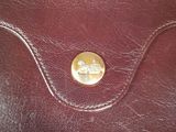 an image of a brown leather wallet with a gold button