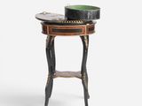 a black and gold side table with a bowl on top of it