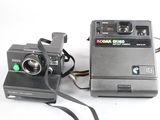 a polaroid camera next to a polaroid camera on a white surface