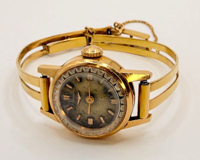 an image of a gold wrist watch with roman numerals on it