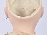 a close up of a doll ' s head with a piece of lace on it