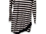 black and white striped shirt hanging on a hanger on a white wall
