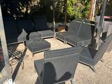 une terrasse avec une table, des chaises et un parasol