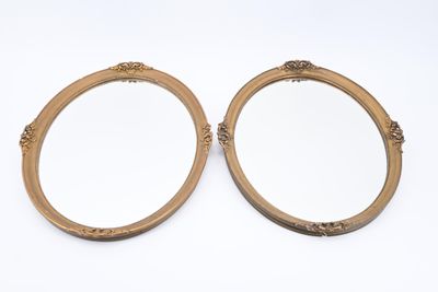 Paire de miroirs en médaillon en bois et stuc doré à décor d…