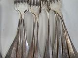 five forks and a spoon on a white plate