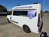 a white van parked in a parking lot with a person taking a picture