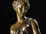 bronze statue of a woman in a dress holding a flower