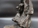 bronze statue of a man holding a child and a dog