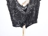 the back of a black top with sequins hanging on a hanger