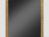 a gold framed mirror on a white wall with a black background