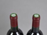 two bottles of wine sitting next to each other on a table