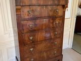 a wooden chest of drawers with marble top in a room