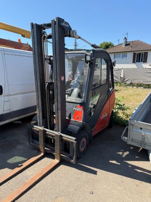 un chariot élévateur garé à côté d'une camionnette blanche