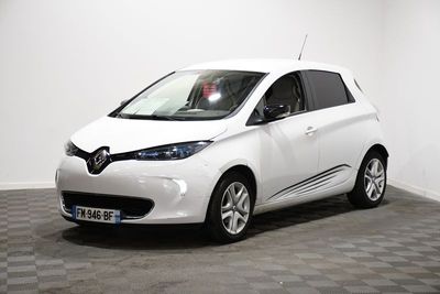 la petite voiture blanche est garée dans une pièce au sol à carreaux