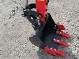 a close up of a red and black skid steer on a gravel road