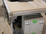 une table sur laquelle est posée une scie, dans une pièce