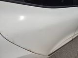 a close up of a white car with a denting on it