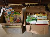 two boxes of books sitting on the floor next to a table