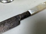a knife that is sitting on a counter next to a cup