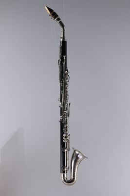 a close up of a saxophone hanging from a string on a wall